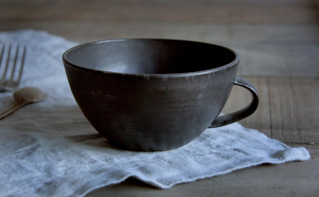 Handmade Pottery Latte Cup in Black on Napkin