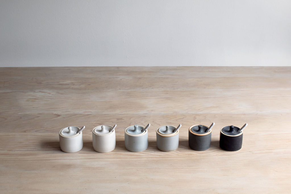 Row of Farmhouse Pottery Collection Spice Jars on Table